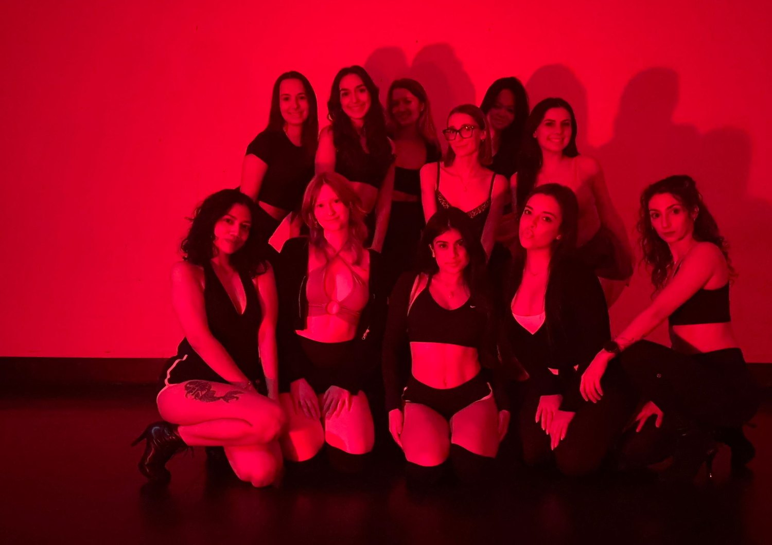 Students together in front of the studio mural