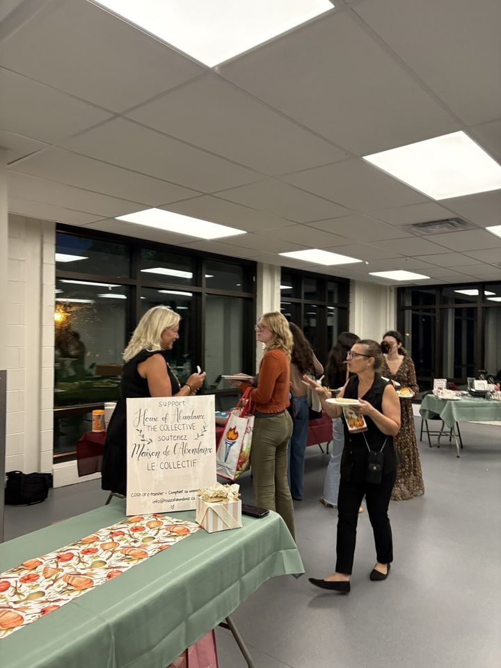 Women chatting near the welcome table on the evening of the first gathering